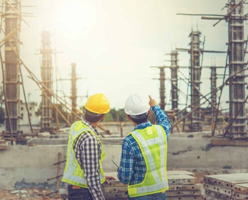 two-workers-discussing-work-at-a-construction-site